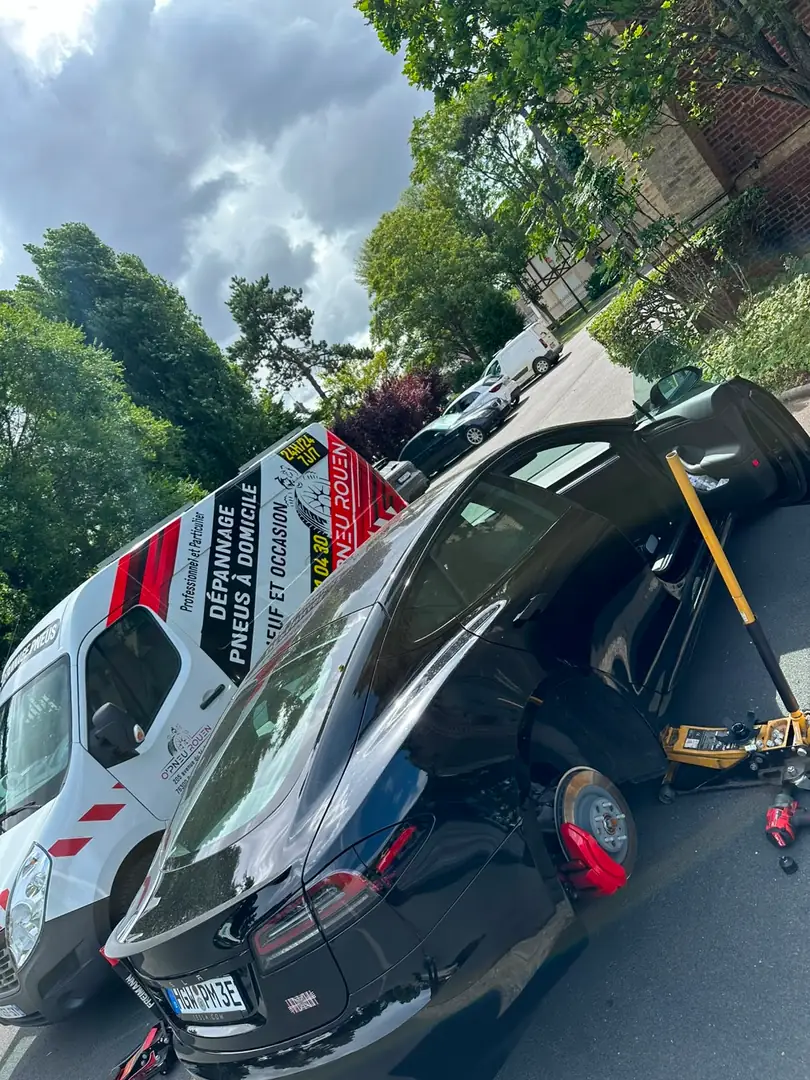 Tesla Model 3 sur cric, roue déposée, devant le camion-atelier O'Pneus Rouen